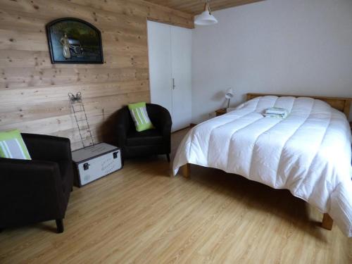 une chambre avec un grand lit et une chaise dans l'établissement Résidence Meije - APPARTEMENT 2 pièces + hall habitable -ALPE D'HUEZ CENTRE STATION MAE-3341, à Huez