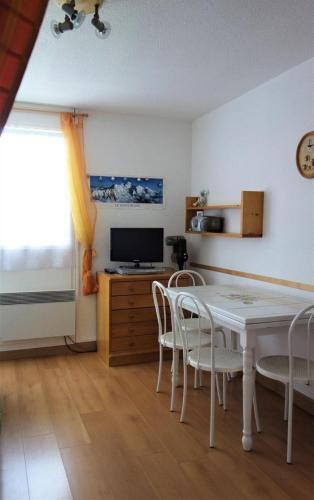 une salle à manger avec une table et des chaises blanches dans l'établissement Résidence Grand Sud - 2 PIECES + HALL HABITABLE-ALPE D'HUEZ ECLOSE EST MAE-3351, à Huez