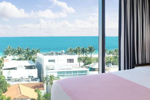 a bedroom with a view of the ocean at Moxy Miami South Beach in Miami Beach