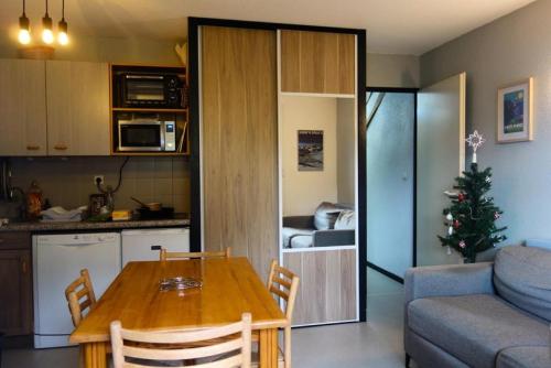 une cuisine et un salon avec une table et un arbre de Noël dans l'établissement Résidence Ecrin D 'huez - APPARTEMENT ALPE D'HUEZ DANS QUARTIER BERGERS MAE-3431, à Huez
