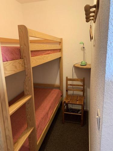 Cette chambre comprend 2 lits superposés et une chaise. dans l'établissement Résidence Balcons D'huez - appartement 2 coins montagne ALPE D'HUEZ QUARTIER ECLOSE EST MAE-3441, à Huez