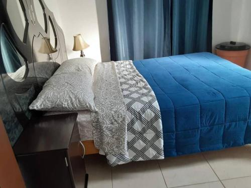 a bedroom with a bed with a blue blanket on it at Departamento en Nuevo Altata in Isla de Redo