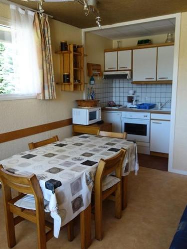 une cuisine avec une table et des chaises dans une cuisine dans l'établissement Résidence Saint Bernard - APPARTEMENT ALPE D'HUEZ QUARTIER CENTRE STATION MAE-3471, à Huez
