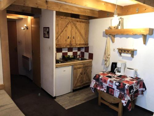 - une cuisine avec des placards en bois et une table dans une pièce dans l'établissement Résidence Grand Sud - Studio de 20 m² avec mezzanine-ALPE D'HUEZ ECLOSE EST MAE-3481, à Huez