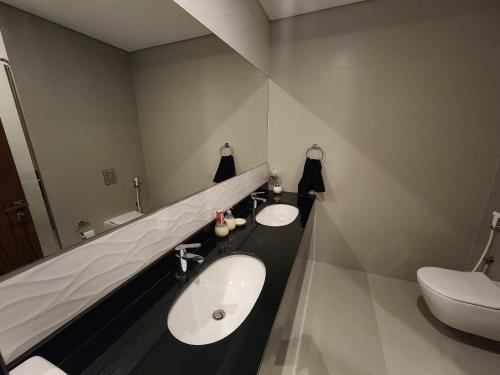 a bathroom with two sinks and a mirror and a toilet at 3-BR Sea View Duplex on Island in Sanābis