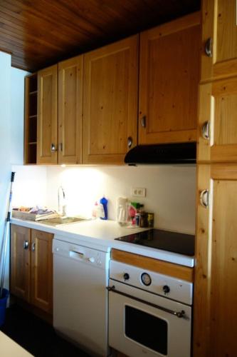 Il comprend une cuisine équipée d'une cuisinière blanche et d'un évier. dans l'établissement Résidence Alpe 2000 - APPARTEMENT 2 Pièces + coin montagne -ALPE D'HUEZ HAUT DE STATION MAE-3511, à Huez