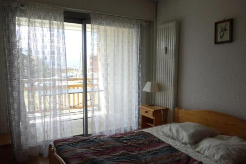 une chambre avec un lit et une fenêtre avec un balcon dans l'établissement Résidence Alpe 2000 - APPARTEMENT 2 Pièces + coin montagne -ALPE D'HUEZ HAUT DE STATION MAE-3511, à Huez