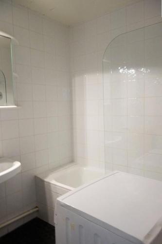 une salle de bain blanche avec une baignoire et un lavabo dans l'établissement Résidence Alpe 2000 - APPARTEMENT 2 Pièces + coin montagne -ALPE D'HUEZ HAUT DE STATION MAE-3511, à Huez