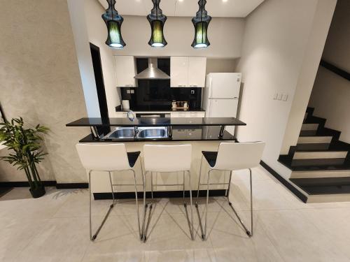 a kitchen with a counter and some white appliances at 3-BR Sea View Duplex on Island in Sanābis