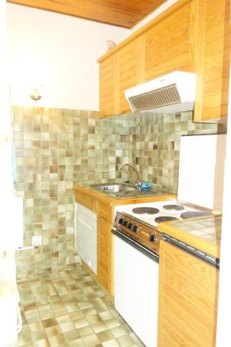 une cuisine avec un évier et une cuisinière four supérieur dans l'établissement Résidence Azur - APPARTEMENT 2 PIECES + COIN MONTAGNE- ALPE D'HUEZ AVENUE DU RIF NEL MAE-3571, à Huez