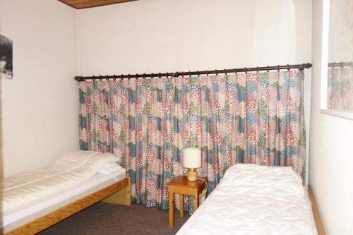 - 2 lits jumeaux dans une chambre avec rideau dans l'établissement Résidence Azur - APPARTEMENT 2 PIECES + COIN MONTAGNE- ALPE D'HUEZ AVENUE DU RIF NEL MAE-3571, à Huez