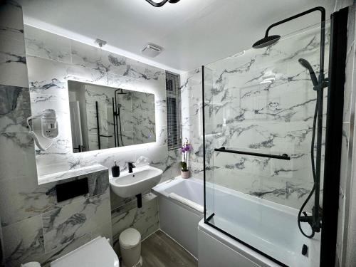 a white bathroom with a sink and a shower at Holly Tree House in Cambridge