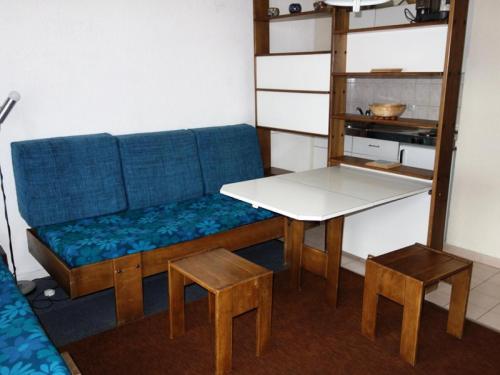 un salon avec un canapé bleu et une table dans l'établissement Résidence Kandahar - APPARTEMENT ALPE D'HUEZ AVENUE DU RIF NEL MAE-3621, à Huez