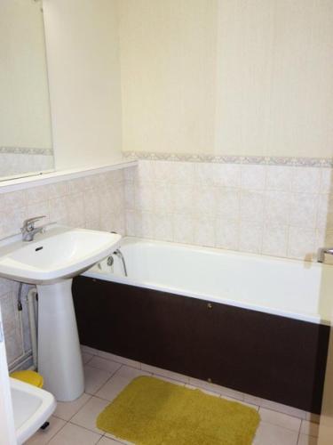 La salle de bains est pourvue d'un lavabo et d'une baignoire à côté des toilettes. dans l'établissement Résidence Kandahar - APPARTEMENT ALPE D'HUEZ AVENUE DU RIF NEL MAE-3621, à Huez