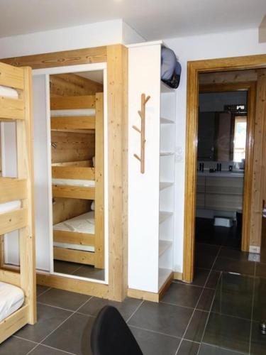 Cette chambre comprend des lits superposés en bois et une cuisine. dans l'établissement Résidence Res.de L'alpe - APPARTEMENT ALPE D'HUEZ CENTRE STATION MAE-3631, à Huez