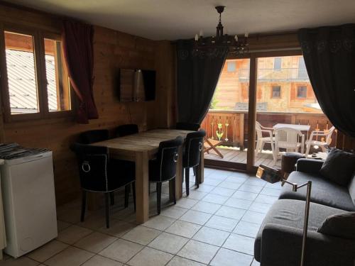 une salle à manger avec une table et des chaises en bois dans l'établissement Chalet Alpina - APPARTEMENT ALPE D'HUEZ QUARTIER HAUT DE STATION MAE-3671, à Huez