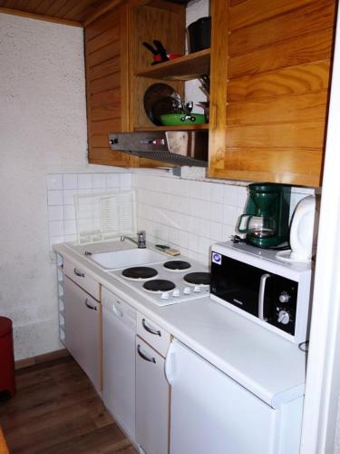 une cuisine avec une cuisinière blanche et un micro-ondes dans l'établissement Résidence Montana - APPARTEMENT ALPE D'HUEZ HAUT DE STATION MAE-3681, à Huez