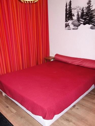 Ce lit se trouve dans un dortoir doté de rideaux rouges. dans l'établissement Résidence Montana - APPARTEMENT ALPE D'HUEZ HAUT DE STATION MAE-3681, à Huez