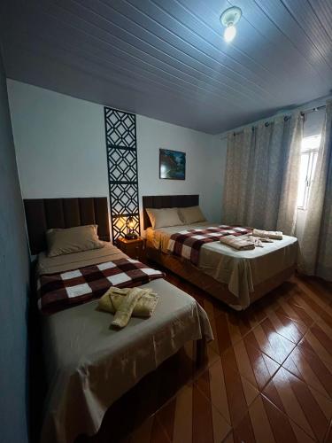 a bedroom with two beds in a room at Casa Montanhas do Caparaó in Caparaó Velho
