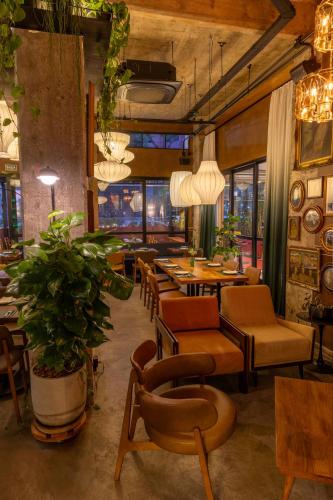a restaurant with chairs and tables and a plant at San Raphael Hotel in Sao Paulo