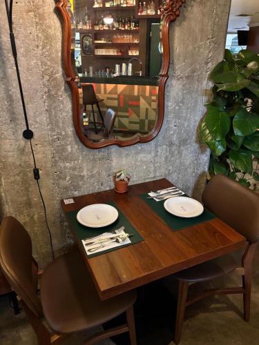 a wooden table with two chairs and a mirror at San Raphael Hotel in Sao Paulo