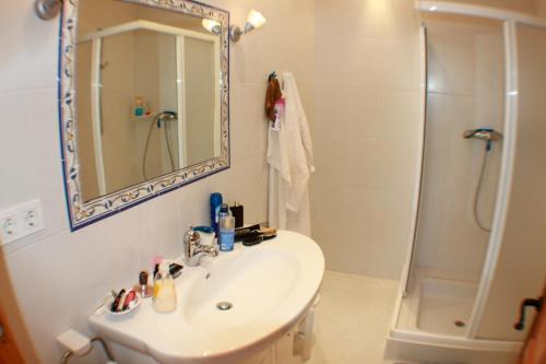 y baño con lavabo y ducha con espejo. en Luz - holiday apartment in peaceful surroundings in Benissa, en Benissa