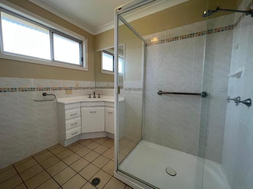 a bathroom with a shower and a sink at Whispering Pines Unit 3, 7 Waratah Lane Evans Head in Evans Head