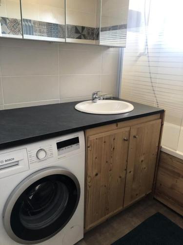 une salle de bain avec un lavabo et une machine à laver dans l'établissement Résidence Sarenne - APPARTEMENT 3 Pièces ALPE DHUEZ CENTRE STATION MAE-3031, à Huez