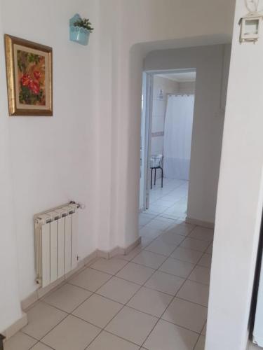 a hallway with white walls and a tile floor at Patagonia Relax- Depto zona céntrica y de servicios de salud in Comodoro Rivadavia