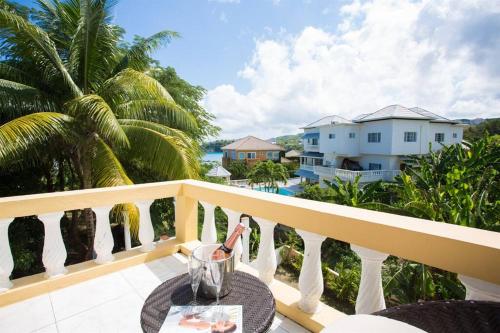 Una mesa en un balcón con vista al mar. en Villa Serenity Jamaica, en Tower Isle
