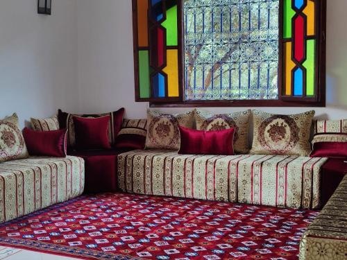 a living room with a couch and stained glass windows at Tissi House in Tahannout
