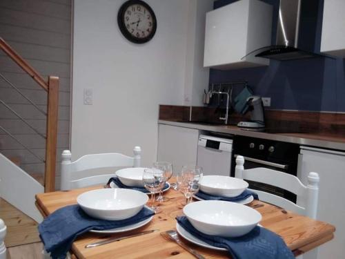 - une cuisine avec une table en bois, des bols et des verres à vin dans l'établissement Gîte LE BIVOUAC, à Fécamp