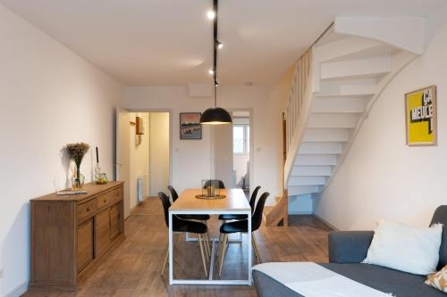 Il comprend une cuisine et un salon avec une table et un escalier. dans l'établissement Au Bercail Mâconnais - Hypercentre - Proche gare - Confort - 8 personnes, à Mâcon