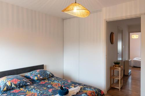 une chambre avec un lit sur lequel est assis un chat dans l'établissement Au Bercail Mâconnais - Hypercentre - Proche gare - Confort - 8 personnes, à Mâcon