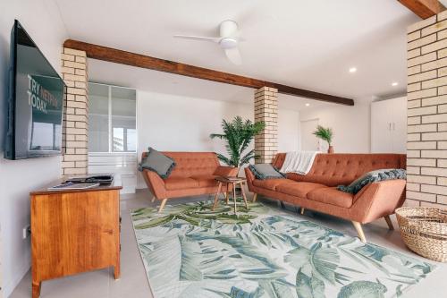 a living room with two couches and a rug at Wave Cave Suite in Coffs Harbour