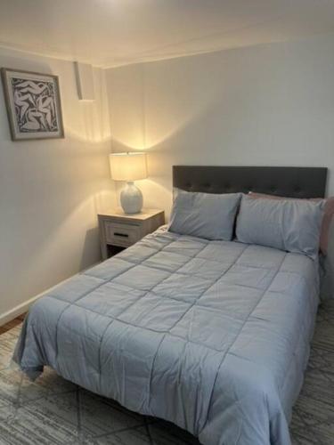 a bedroom with a bed and a night stand with a lamp at Escape to Atlantic City in Atlantic City