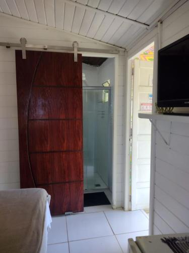 a sliding glass door in a room with a shower at Palhoça da Colina in Fernando de Noronha