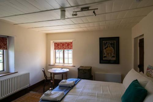 a bedroom with a bed and a table in it at Historic Sandstone Ross Farmhouse in Ross