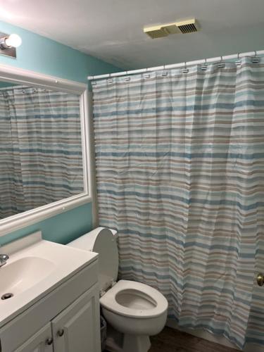 a bathroom with a toilet and a shower curtain at St. Augustine Ocean & Racquet Resort in St. Augustine