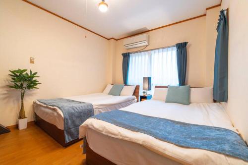 a room with two beds and a window at Mont Hotel Higashi mikuni in Osaka