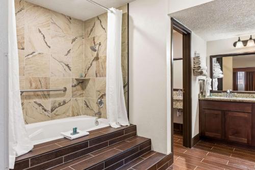 a bathroom with a bath tub and a sink at Best Western Tower West Lodge in Gillette