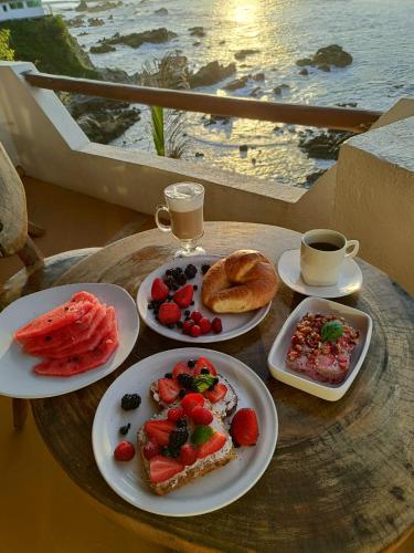 CuatunalcoにあるHotel Luz de Mar ' right on the beachの食べ物の皿とコーヒーカップが置かれたテーブル