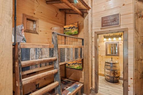 a cabin with a bunk bed in a room with wooden walls at Ace In The Hole in Sevierville
