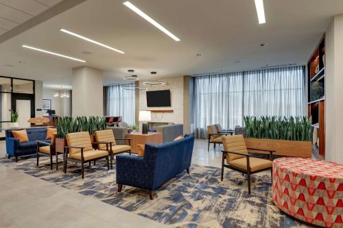 a lobby with chairs and tables and a waiting room at Drury Plaza Hotel Chattanooga Hamilton Place in Chattanooga