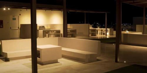 Zimmer mit weißen Möbeln und Blick auf eine Küche in der Unterkunft PLAYA BELLO HORIZONTE "Encanto exclusivo a pasos del Mar" in Playa Bello Horizonte