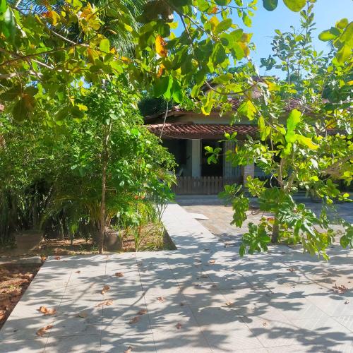 a walkway leading to a house with trees in front at Villa Karina B&B in Itaparica Town