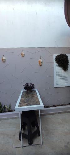 a white table in front of a wall with a window at Casa Seridó - Caicó in Caicó