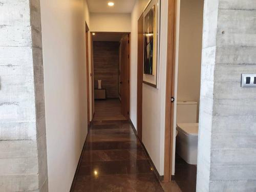 a hallway leading to a bathroom with a toilet at Elegante depa cerca de los arcos con amenidades in Hércules