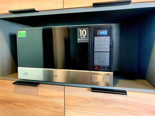 a microwave oven sitting on top of a shelf at Elegante depa cerca de los arcos con amenidades in Hércules