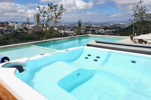 a hot tub in a swimming pool with a city at Elegante depa cerca de los arcos con amenidades in Hércules
